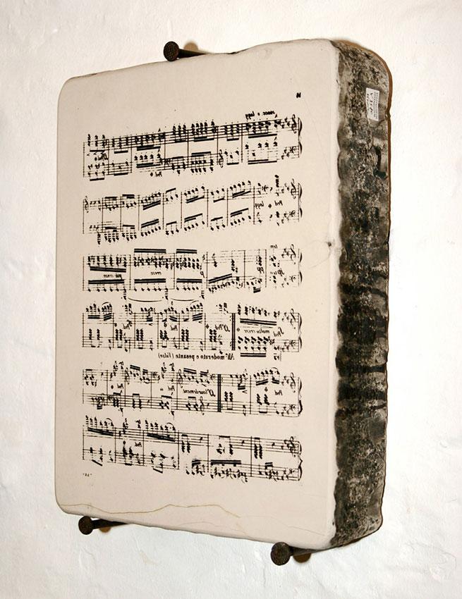 A lithographic stone for printing music. The music is written backwards on the stone.